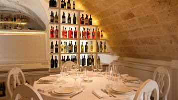 Un restaurante con techo de piedra y una estantería llena de botellas de vino.