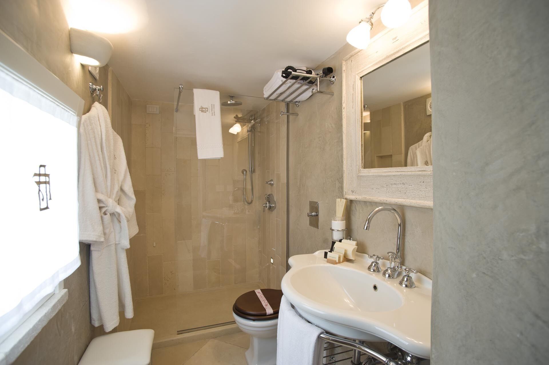 A modern bathroom with a shower, toilet, and sink.