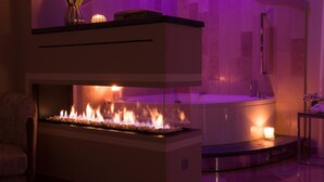 A modern spa area with a heated floor, a bathtub, and a wall-mounted shower.