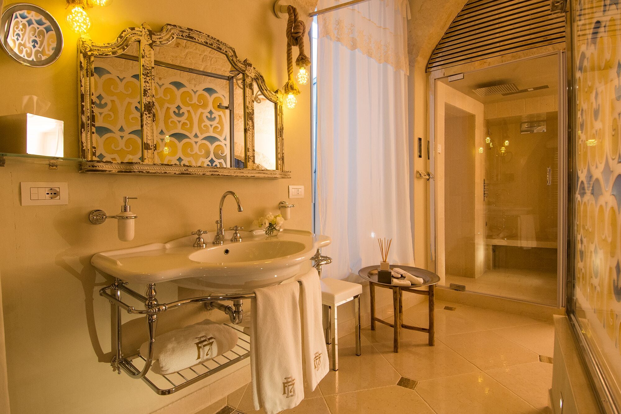 Une salle de bain avec un double lavabo, un miroir, un porte-serviettes et un espace douche.