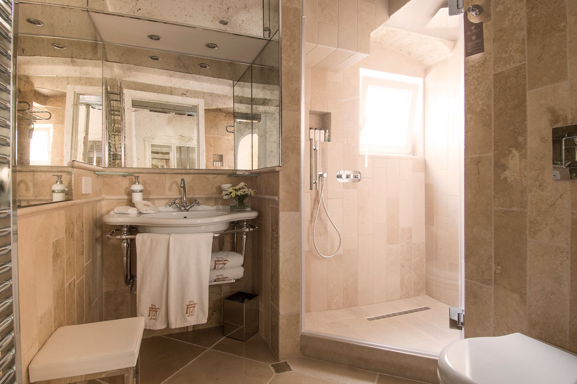 Une salle de bain avec une douche à parois de verre, un lavabo avec un miroir et des toilettes.