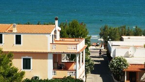 Zona residencial costeira com casas de telhados em cerâmica e varandas viradas para o mar.