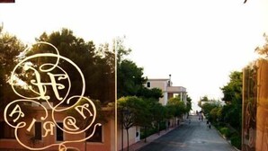 Entrada de hotel com uma escadaria que leva a um pátio.