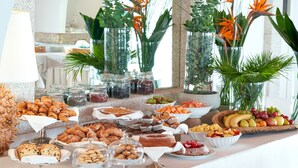 Une table de buffet garnie de divers plats et agrémentée de plantes décoratives.