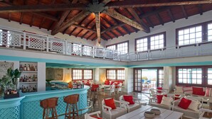 Un grand espace intérieur comprenant un bar, des sièges et une piscine.