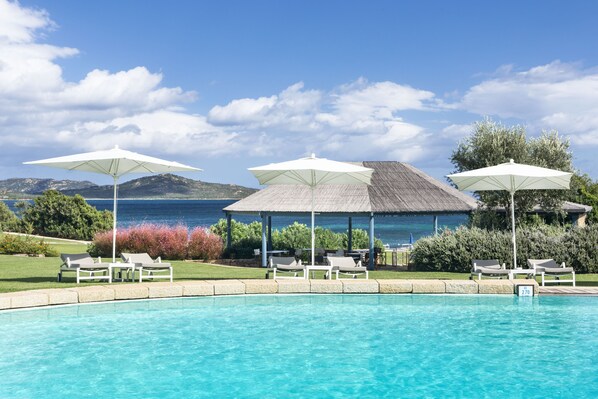 Alberca al aire libre, sombrillas en la alberca y camastros 