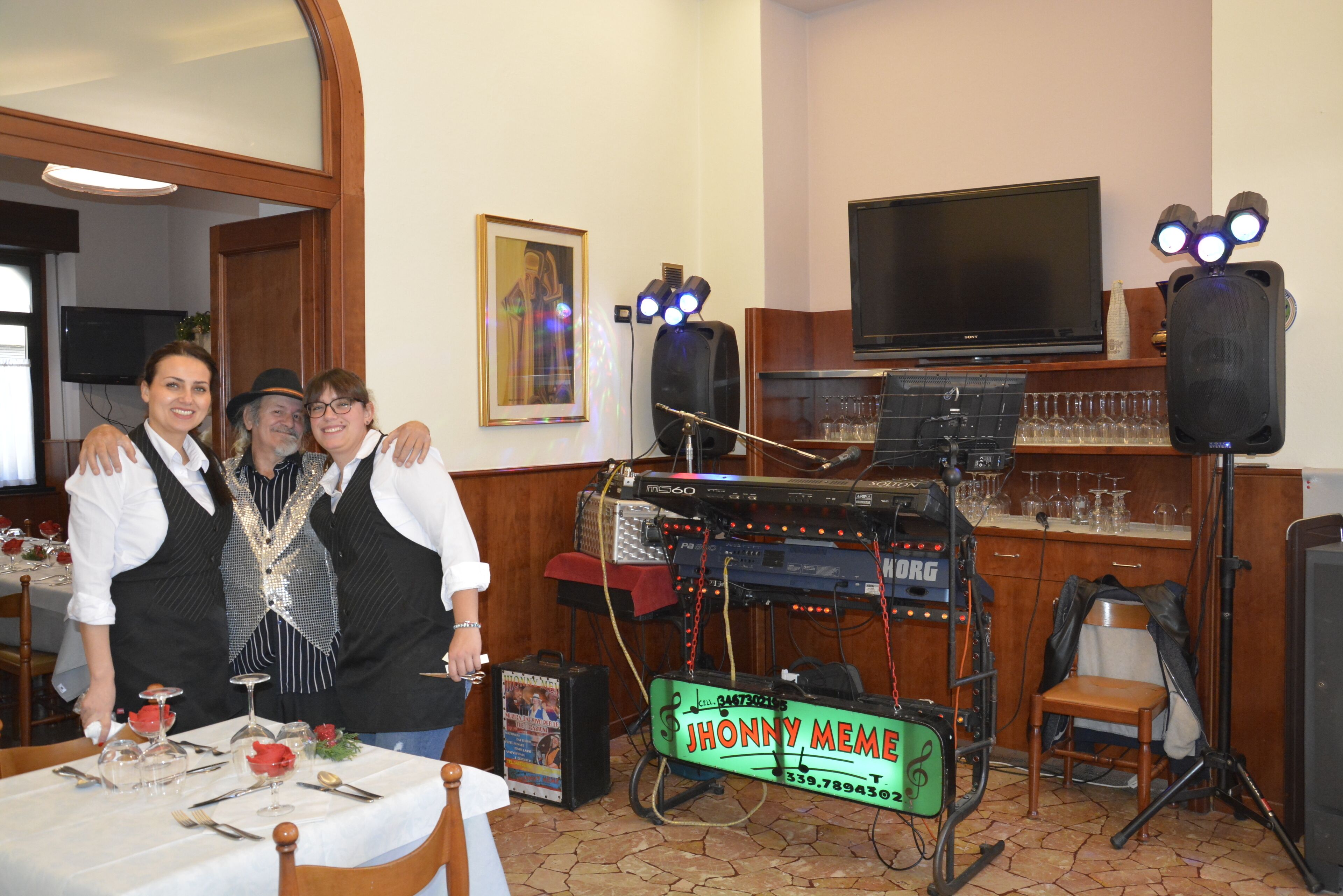A bar area with a DJ setup, a television, and a framed picture on the wall.