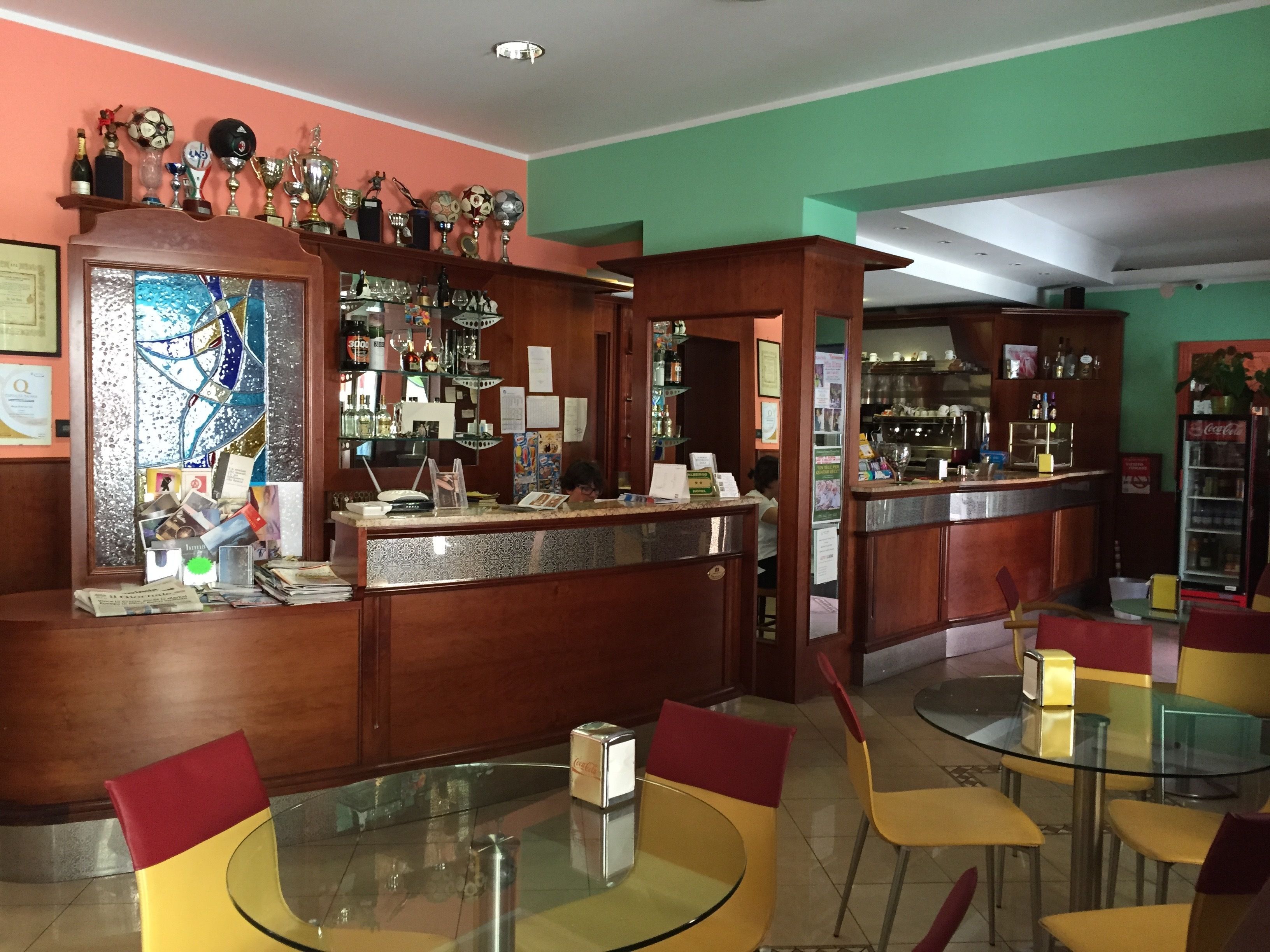 Un área de bar con mostrador, sillas y estantes con diversos objetos.