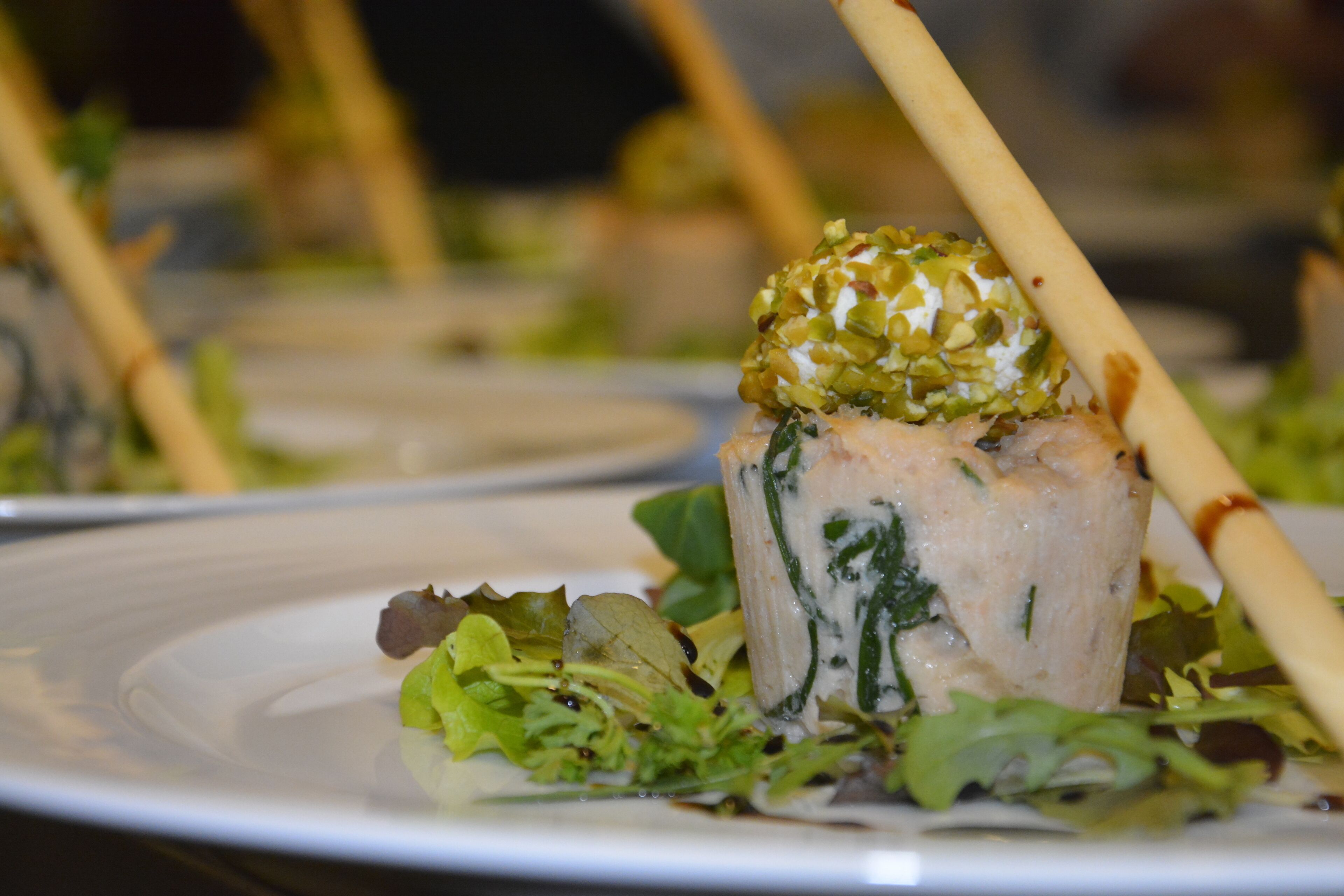 Une vue rapprochée d’un plat, nappé d’une sauce crémeuse et agrémenté d’herbes vertes et d’une quenelle de garniture verte.
