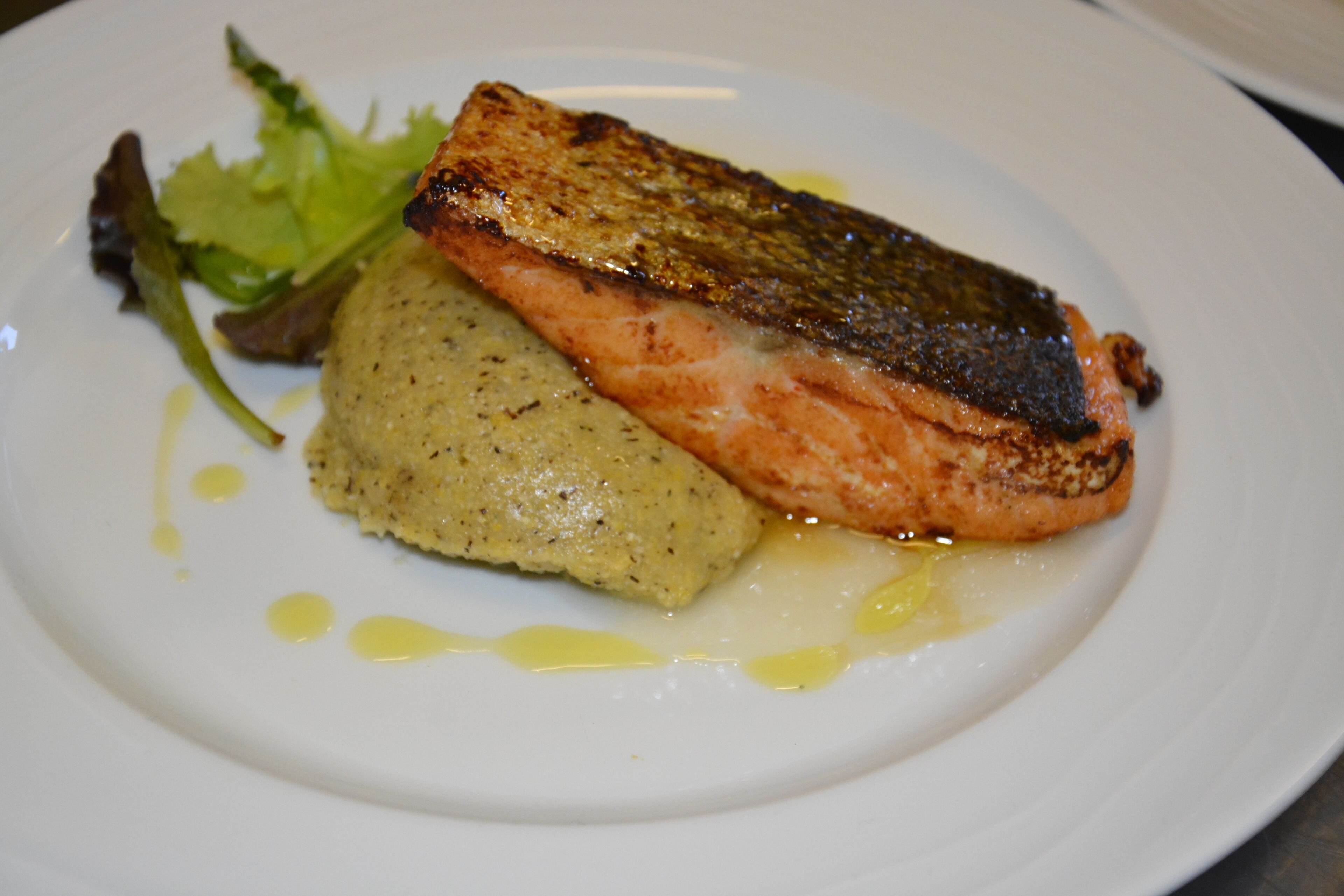 A plate with grilled salmon, mashed potatoes, and a side salad.