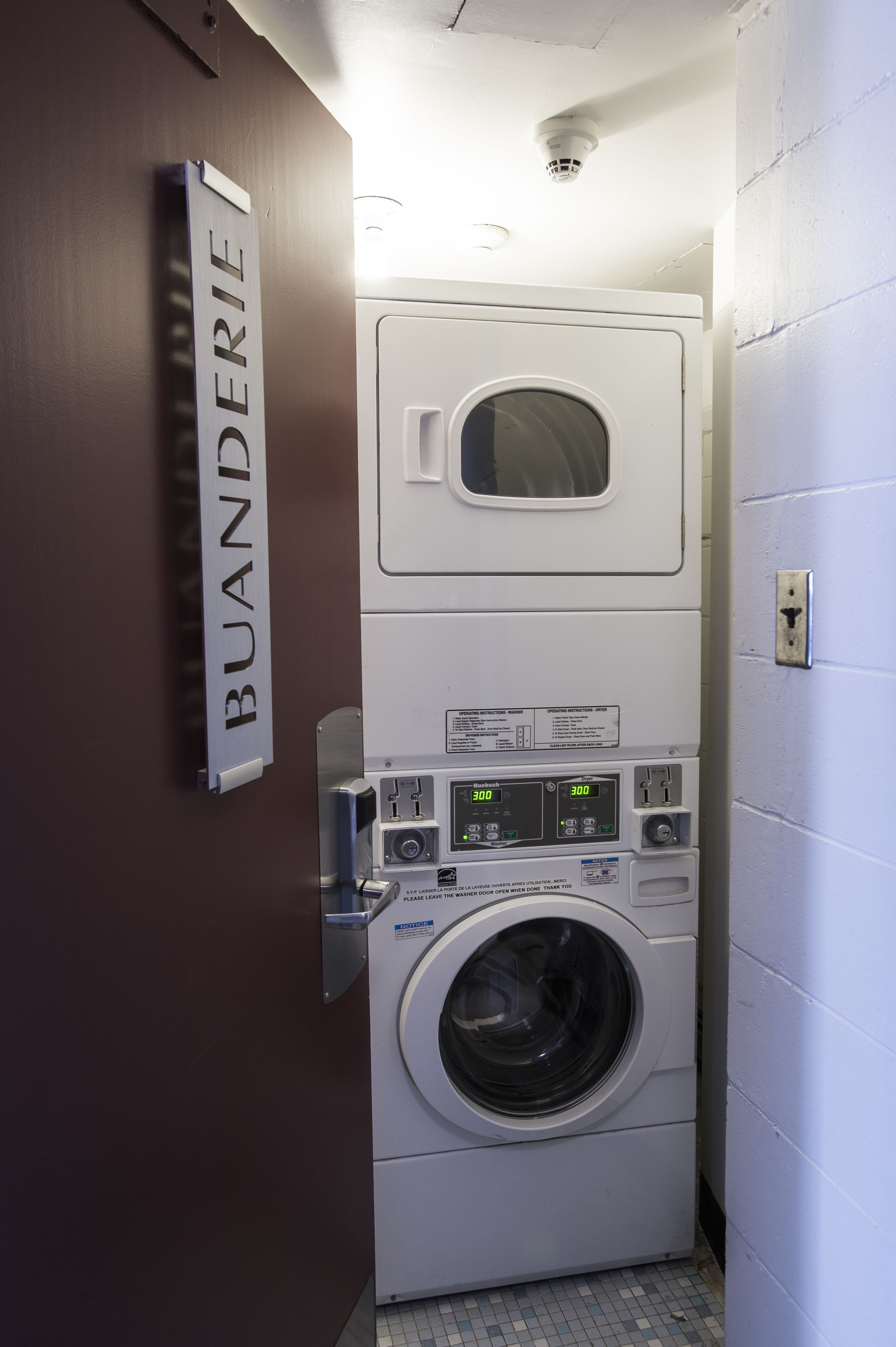 Un espace buanderie compact avec un panneau mural indiquant « BUANDERIE ».