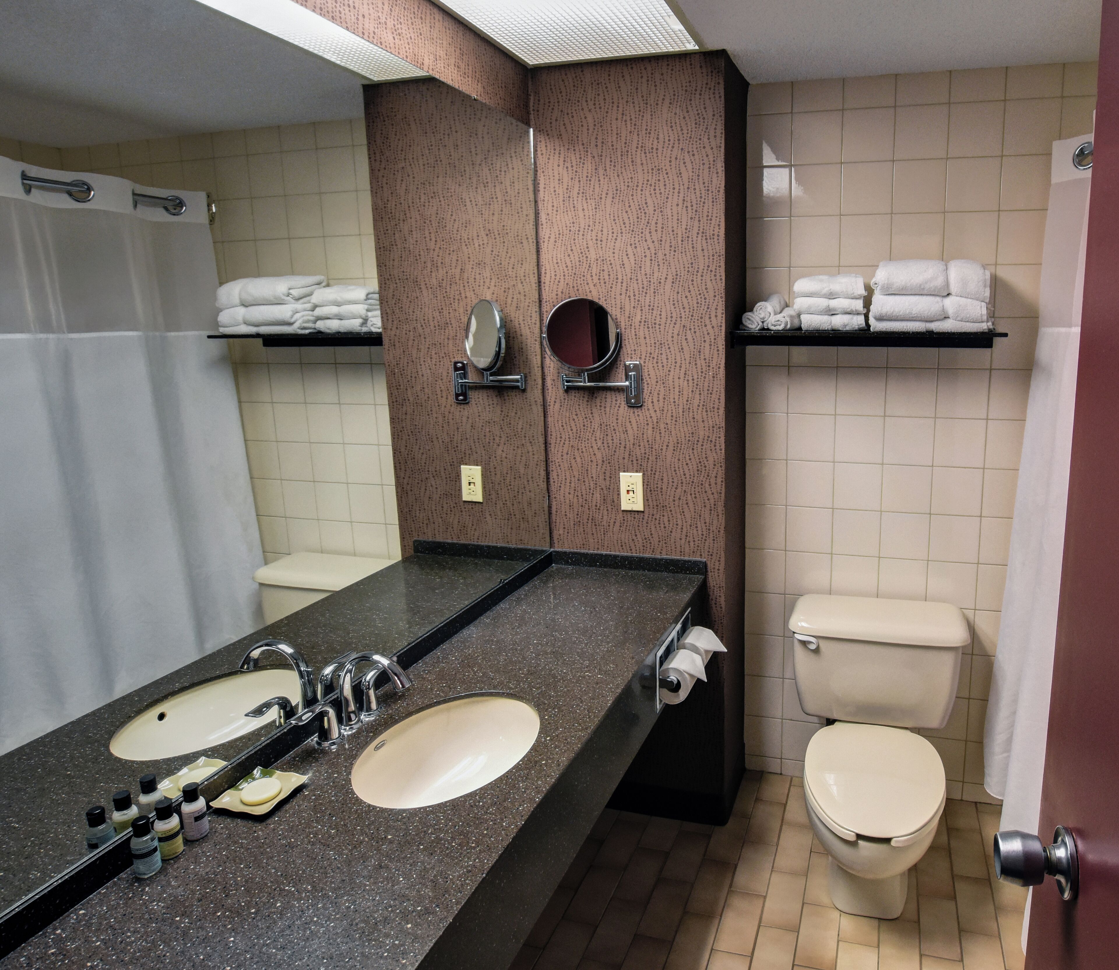 A bathroom with two sinks, a toilet, and a shower.