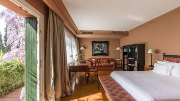 Une chambre d’hôtel avec un lit, un canapé, un bureau et une bibliothèque.