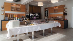 Ein reichhaltiges Buffet mit einer langen Tafel, Gläsern und Speisebehältern.