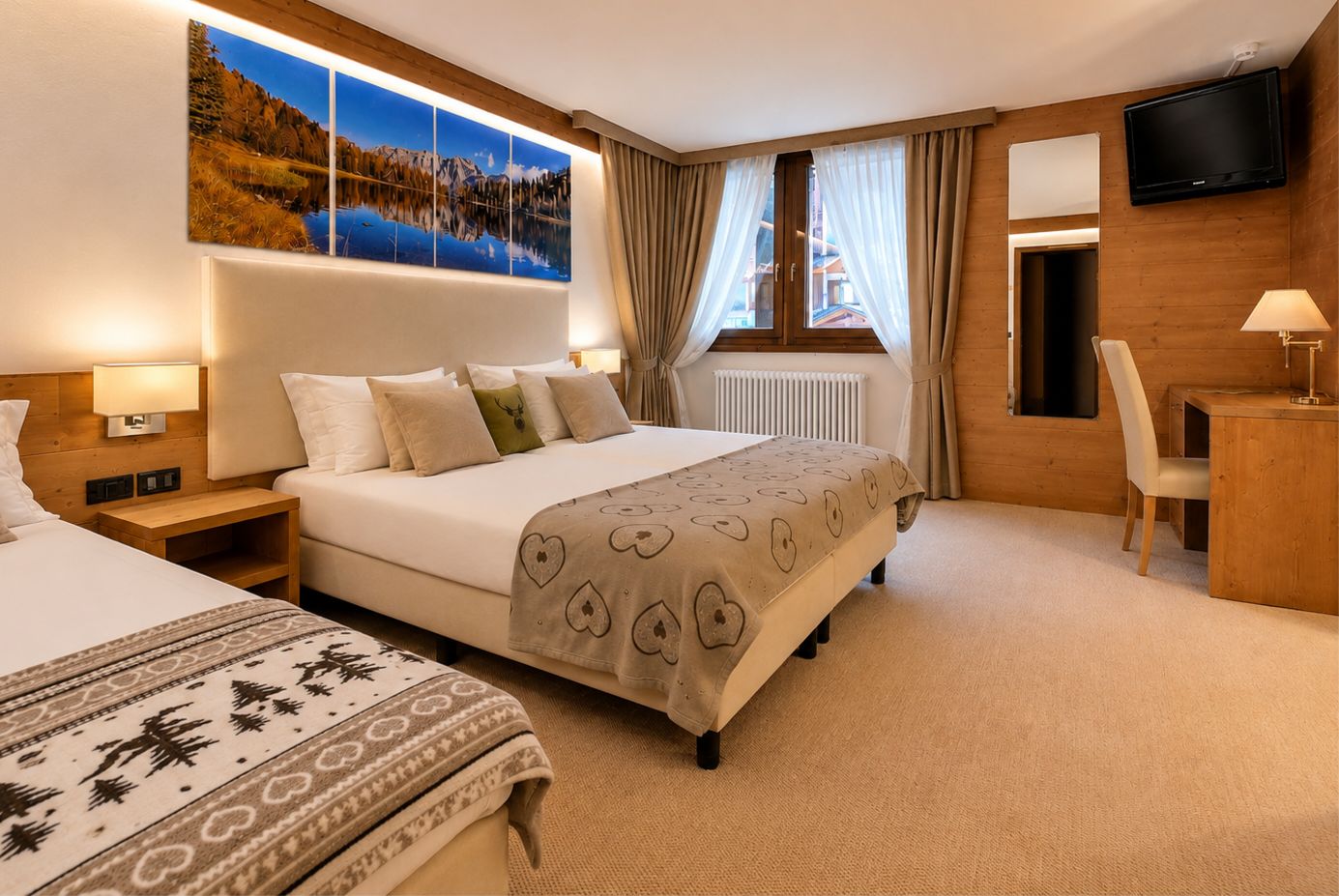 A hotel room with a large bed, a desk, a chair, a TV, and a window with curtains.