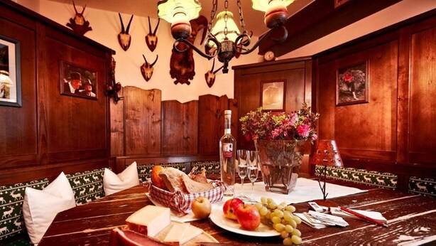 A wooden dining table with a variety of food items, including cheese, meats, fruits, and bread. - Hotel Bergland (Sankt Leonhard im Pitztal)