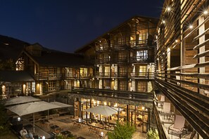 A multi-story building with outdoor seating and a covered patio area. - Le M de Megève (Megeve)