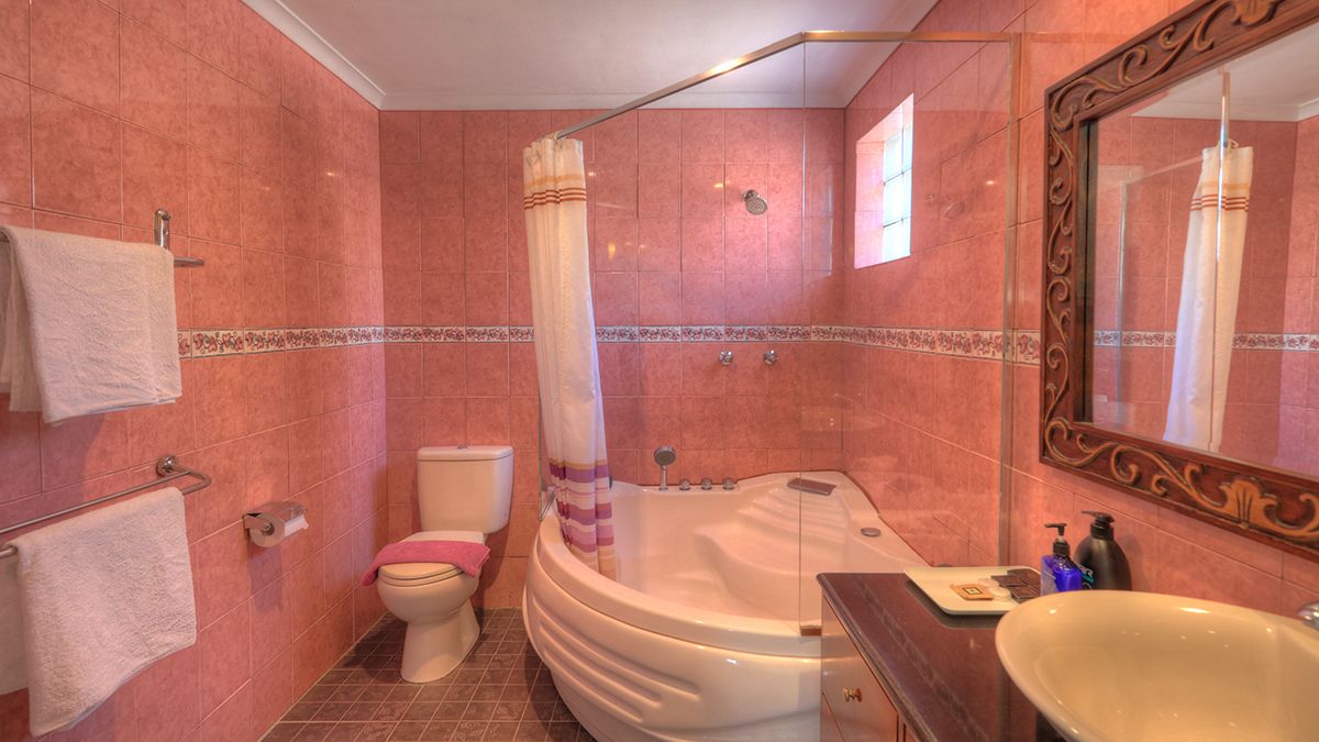 Une salle de bain équipée d’une douche, de toilettes, d’une baignoire et d’un lavabo.