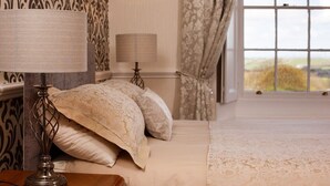 Ein Schlafzimmer mit einem Bett, zwei Nachttischlampen und einem Fenster mit Vorhängen.