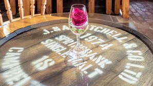 A rustic interior with exposed brick walls, wooden furniture, and a round table with a glass top. - The Wayside and Whisky Barn (Millom)