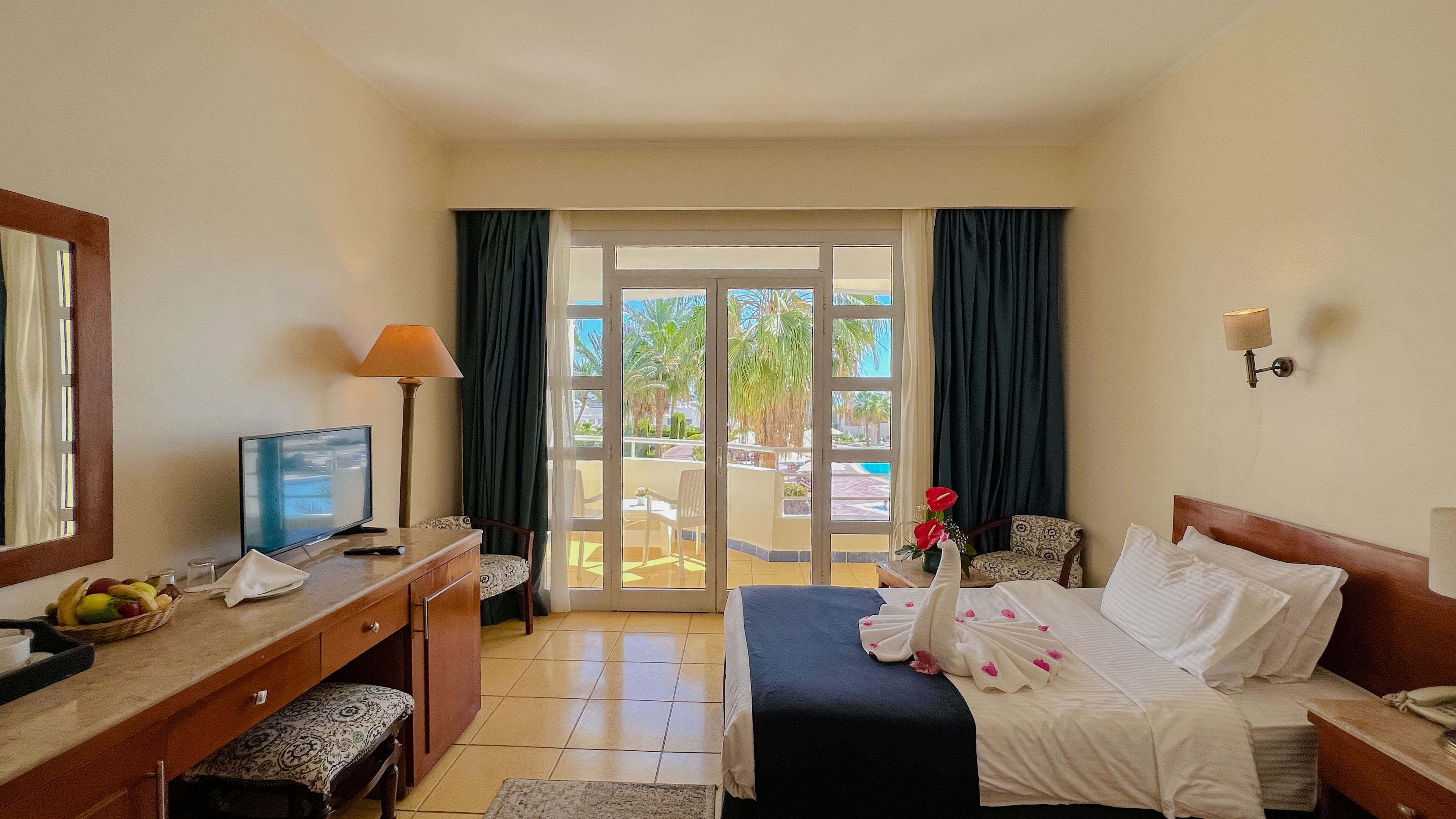 Een hotelkamer met een bed, bureau en uitzicht op het buitengebied.