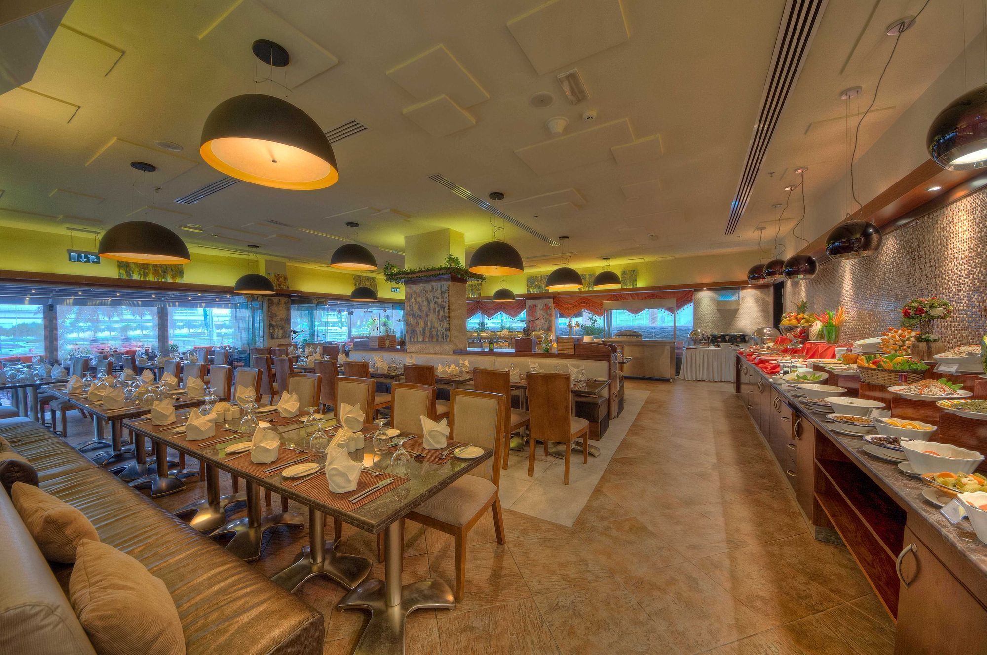 Un restaurant doté de plusieurs tables, de chaises et d’un espace buffet.