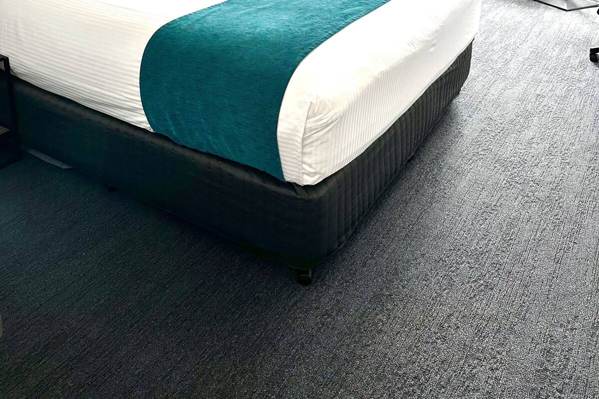 Une chambre d’hôtel avec un grand lit, un bureau et une chaise.