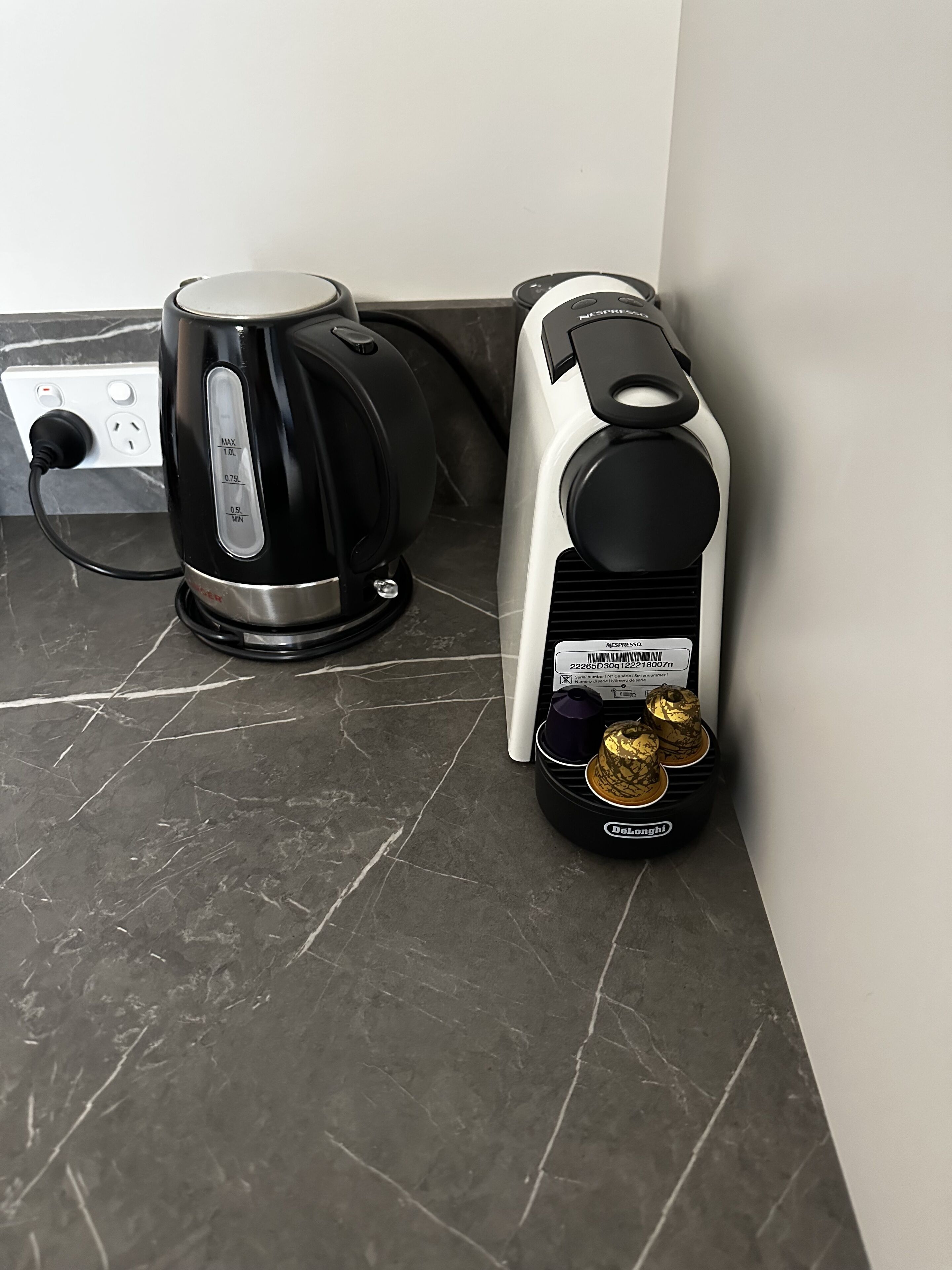 A coffee maker and a toaster on a marble countertop.