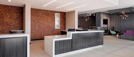A modern reception area with a reception desk, seating area, and patterned walls.
