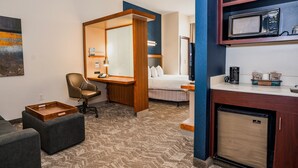 A hotel room with a bed, a desk, a chair, a small kitchenette, and a microwave. - SpringHill Suites by Marriott San Antonio Alamo Plaza/Convention Center (San Antonio)