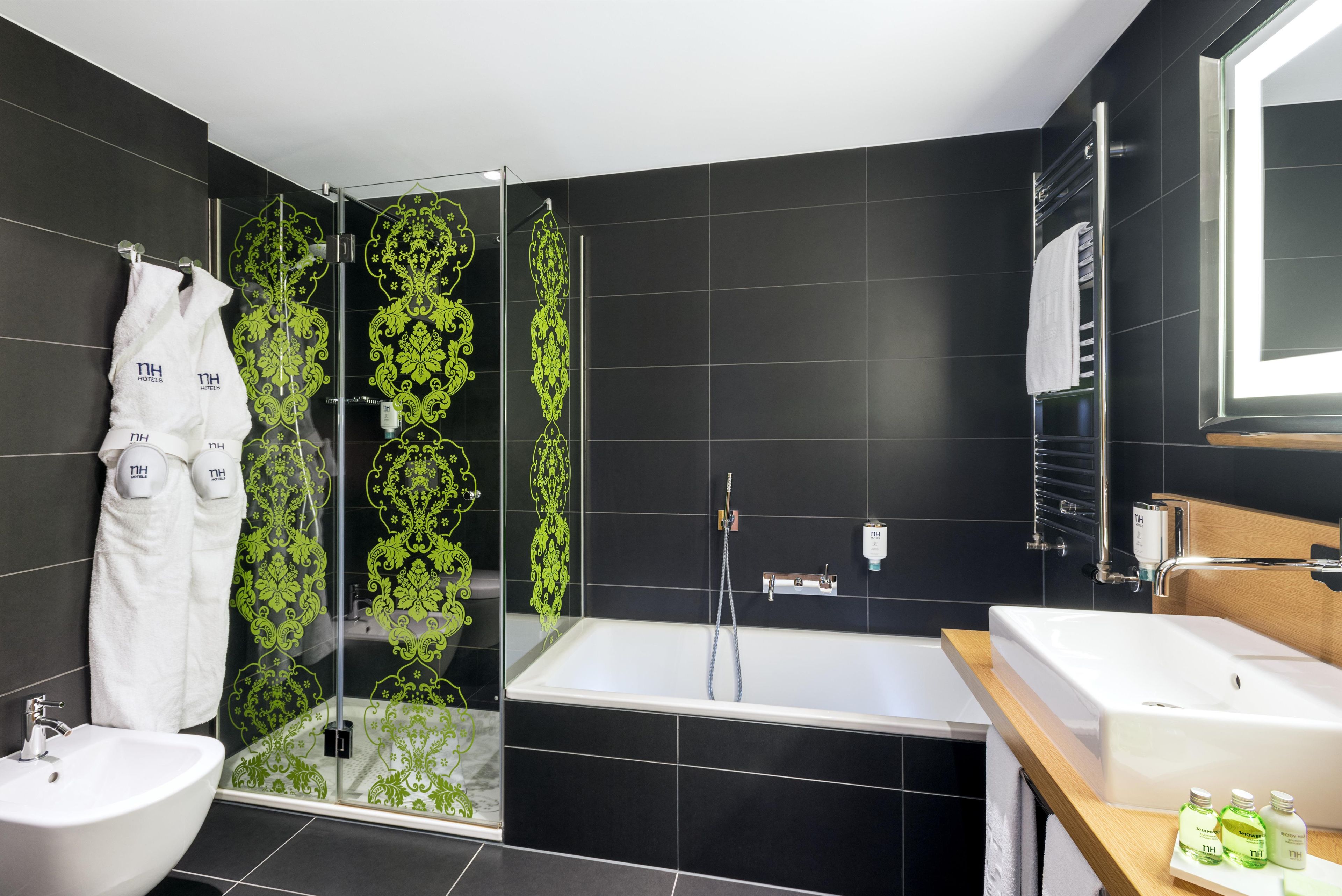 Un baño moderno con ducha envuelta en vidrio, bañera y tocador con lavamanos.
