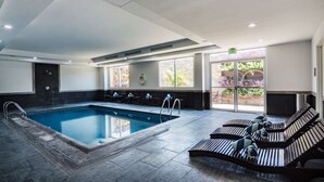 A swimming pool with lounge chairs and a view of greenery outside. - DoubleTree by Hilton Hotel Queretaro (Querétaro)