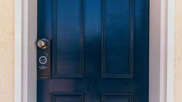 Una puerta azul oscuro con una cerradura y un cartel que dice 'No molestar, gracias'.