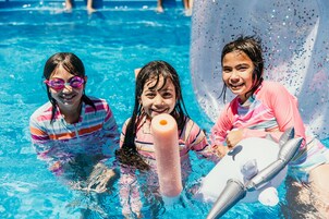 Una piscina al aire libre, sillones reclinables de piscina
