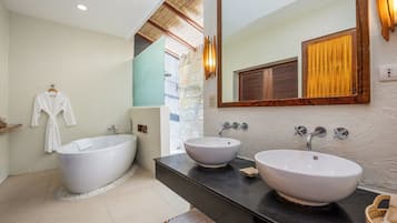 Un baño moderno con una bañera independiente, dos lavamanos, un espejo grande y techo de madera.