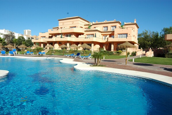 Piscine couverte, piscine extérieure, parasols de plage, chaises longues