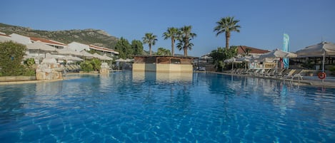 Una piscina al aire libre de temporada, tumbonas