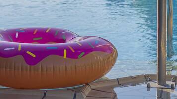Enjoy a refreshing swim in our pool, accessible via the pool ladder, surrounded by shaded seating areas.