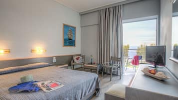 Une chambre d’hôtel avec un lit, un bureau avec un ordinateur, une chaise, une fenêtre avec des rideaux et un tableau au mur.