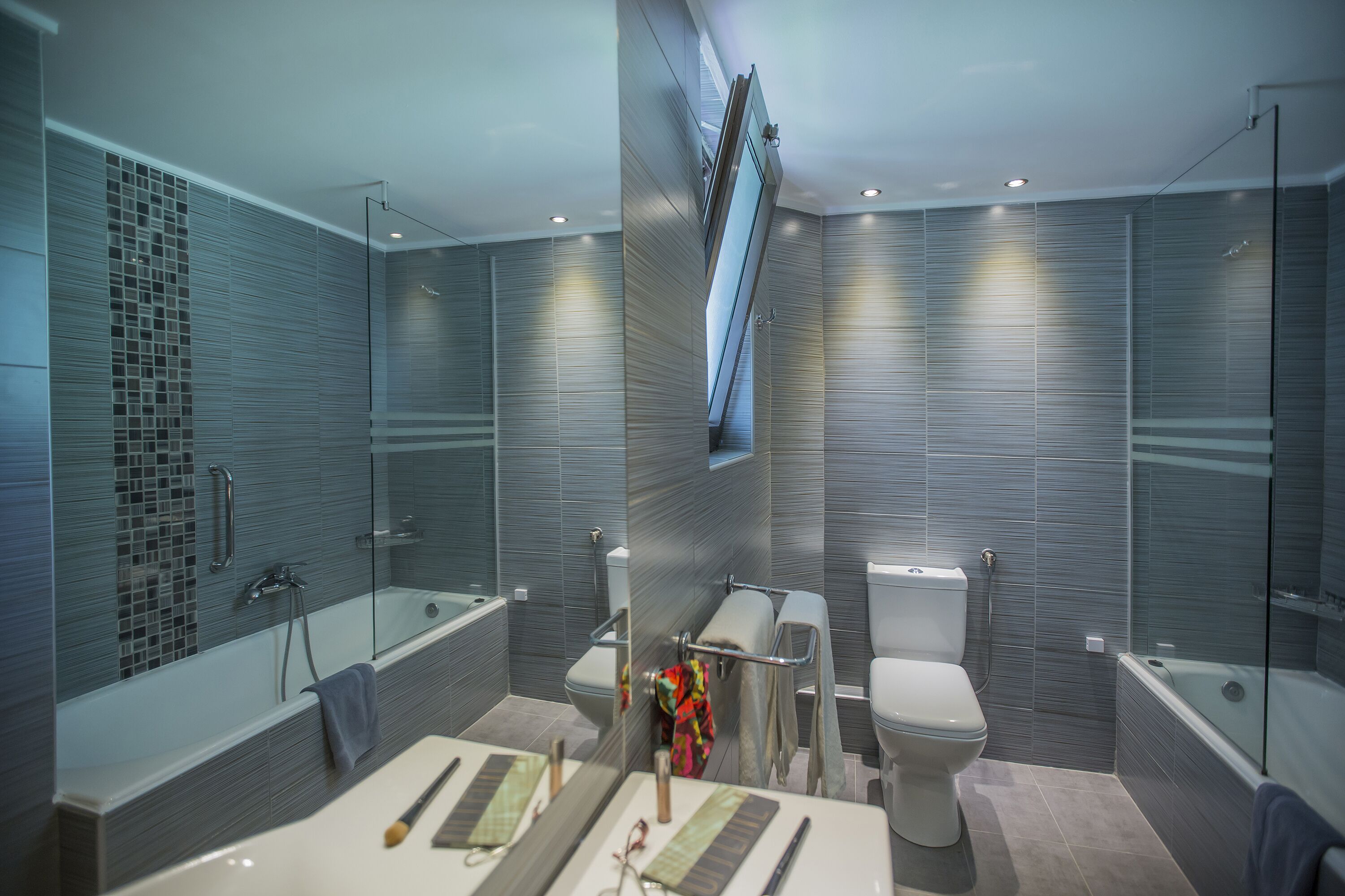 Un baño moderno con ducha de vidrio, una bañera y un inodoro.
