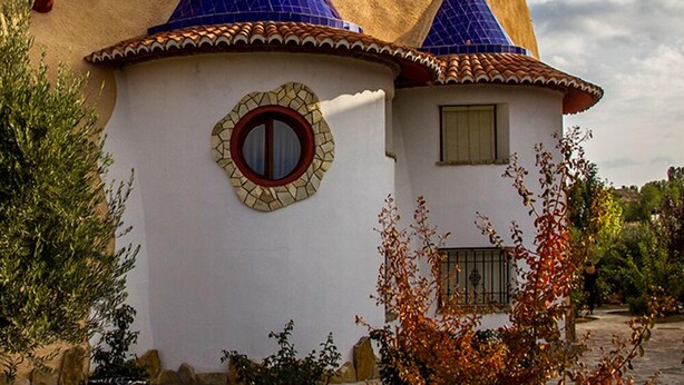 Un edificio con un estilo arquitectónico único, que presenta un ventanal circular y una fachada decorativa.