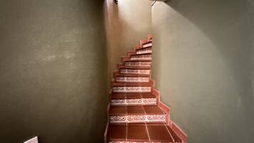 A staircase with ornate red and white tiles leading to a landing.