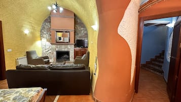 A cozy living area with a fireplace, comfortable seating, and a television.