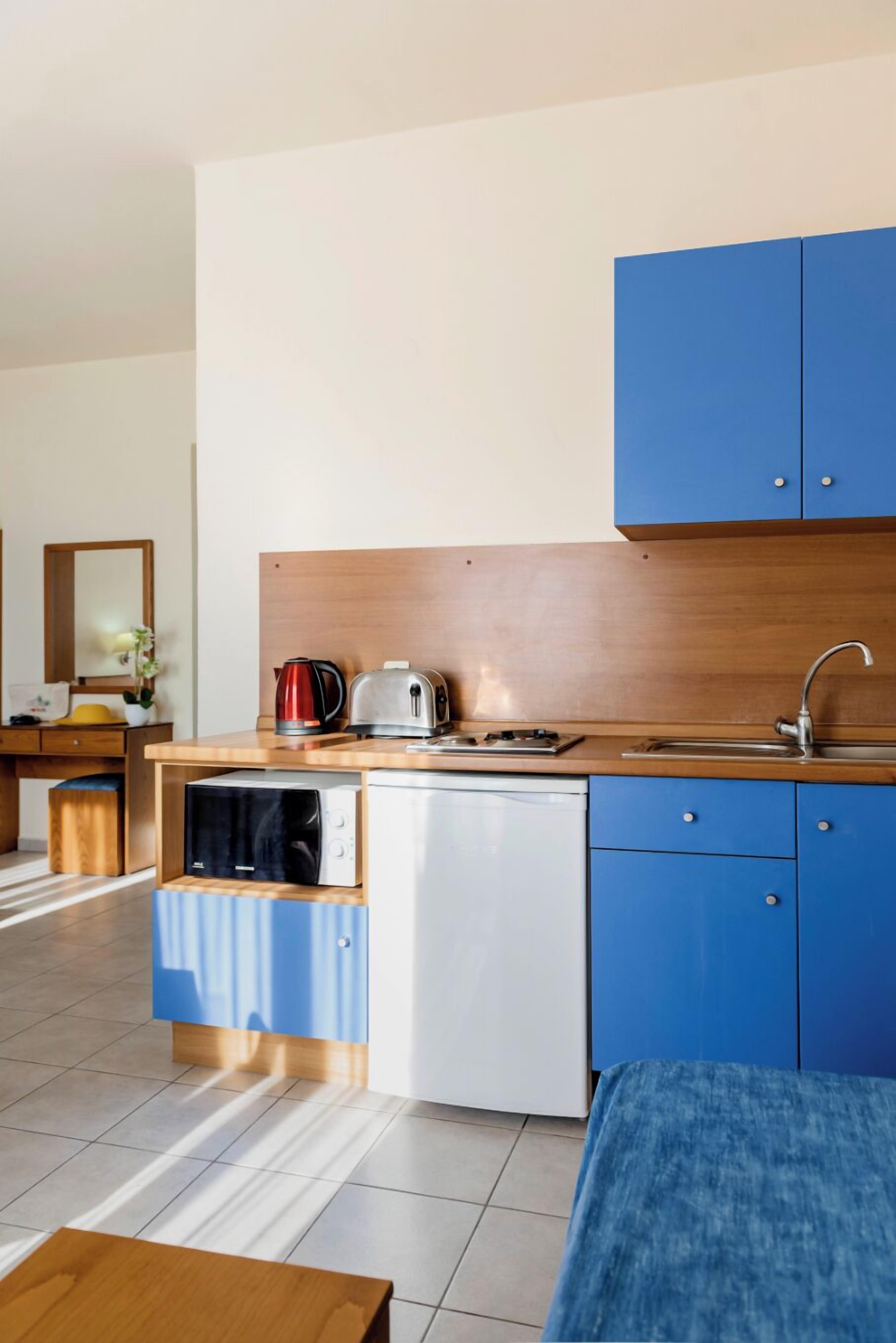 Een koelkast, een koffiezetapparaat/waterkoker, een waterkoker