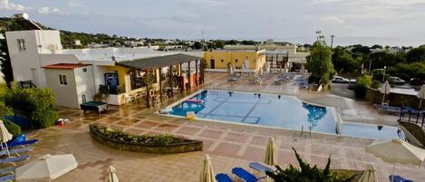 Alberca al aire libre por temporada y sombrillas en la alberca