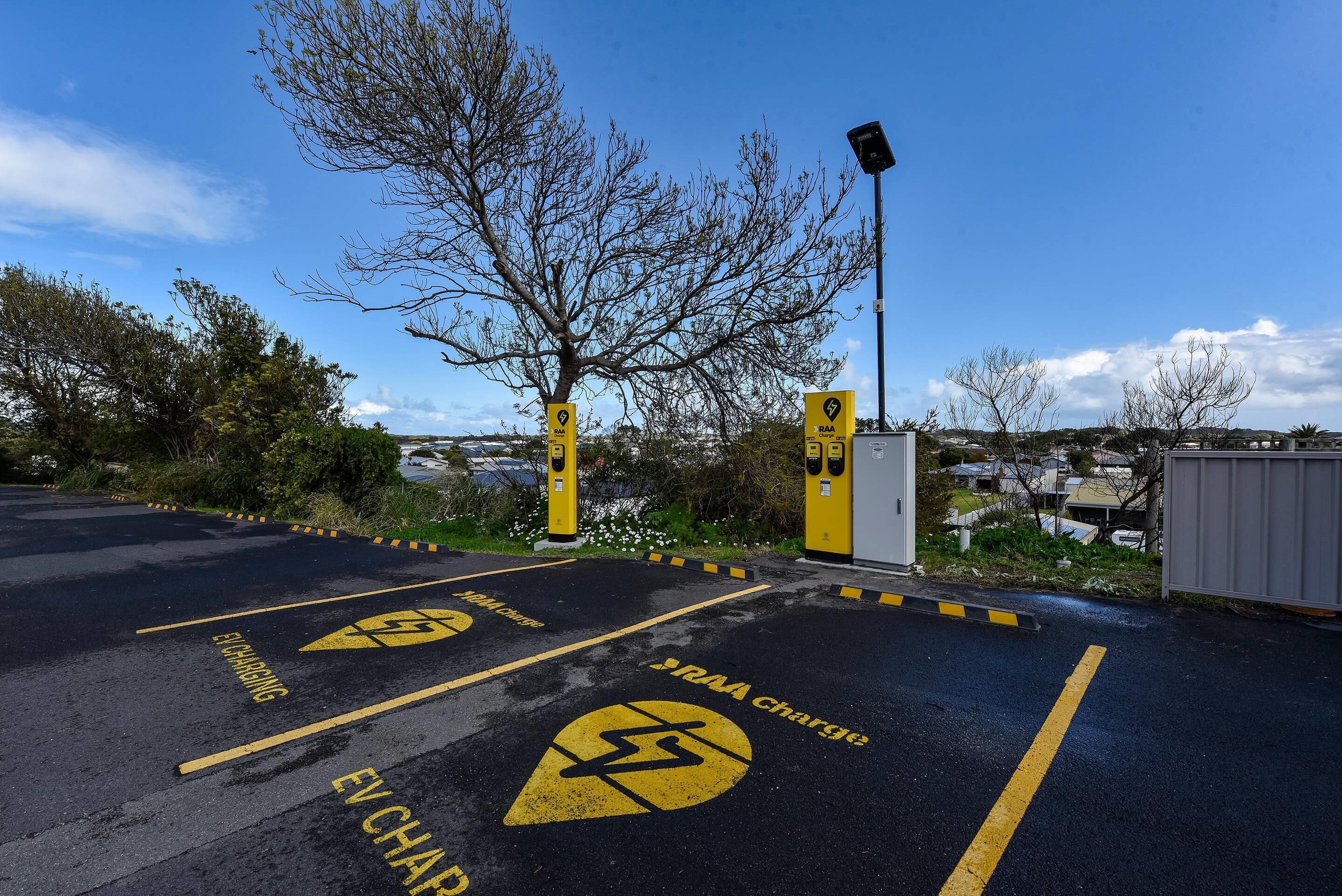 A parking area with EV charging stations and a RAA charge sign.