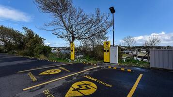 A parking area with EV charging stations and a RAA charge sign.
