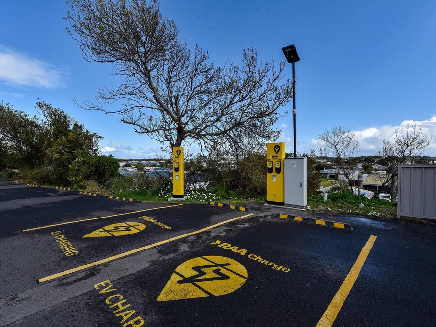 A parking area with EV charging stations and a RAA charge sign.