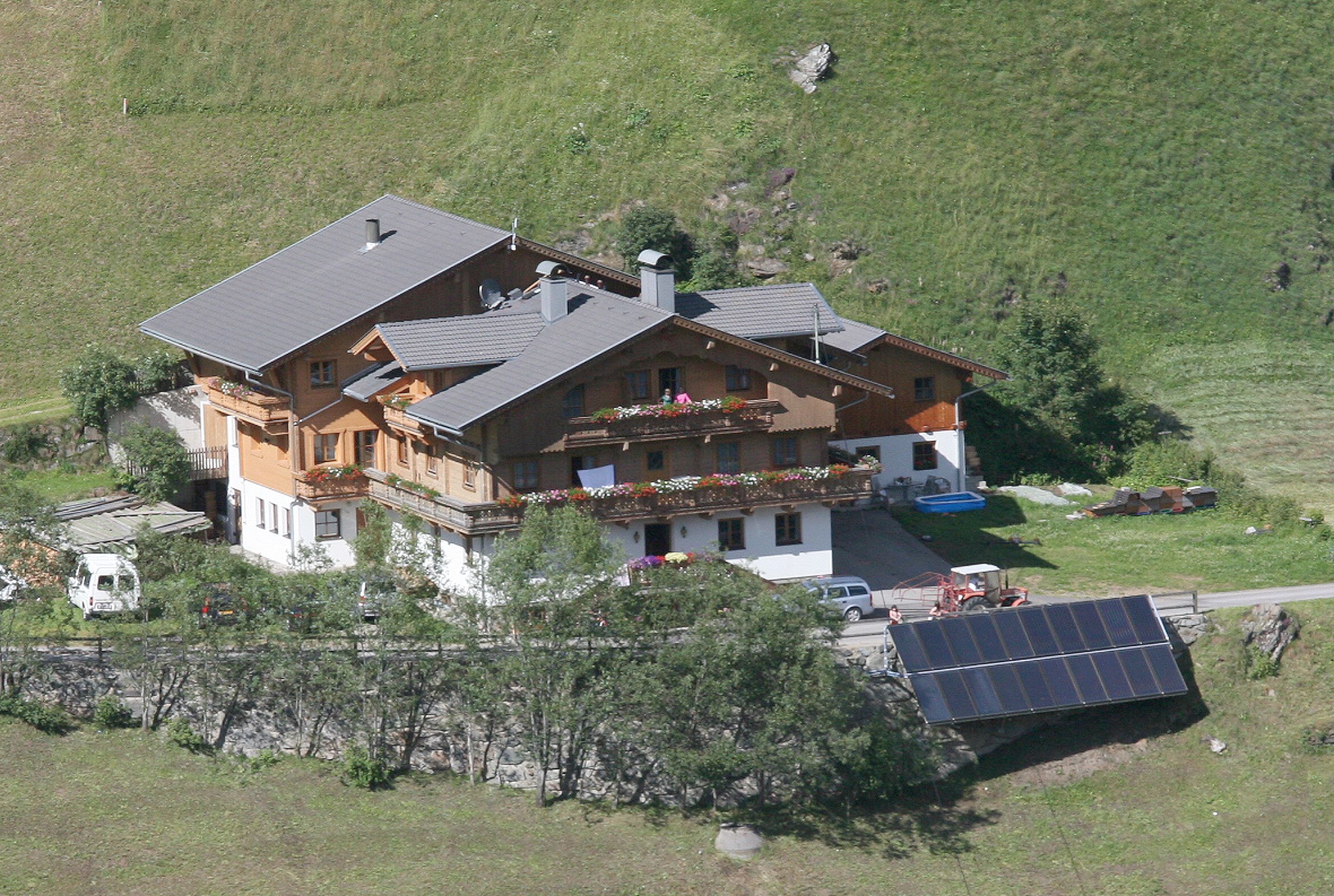 Un grand chalet à plusieurs étages, doté d’un balcon, d’une piscine et d’un panneau solaire.