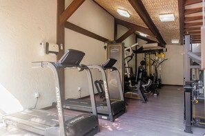 A gym with treadmills, weight machines, and a wall-mounted massage chair. - Rio Buzios Boutique Hotel (Búzios)